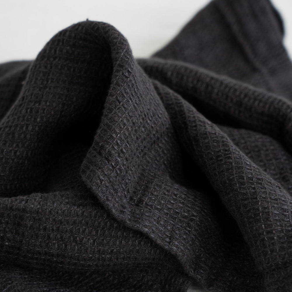 Dark gray textured linen fabric on a white background