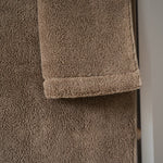 Brown towel on a textured surface with a neutral background