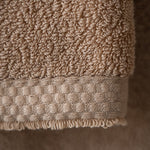 Close-up of a beige textured towel on a neutral background