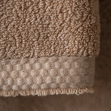 Close-up of a beige textured towel on a neutral background