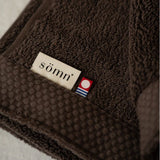 Brown textured fabric with a 'somn' label on a neutral background
