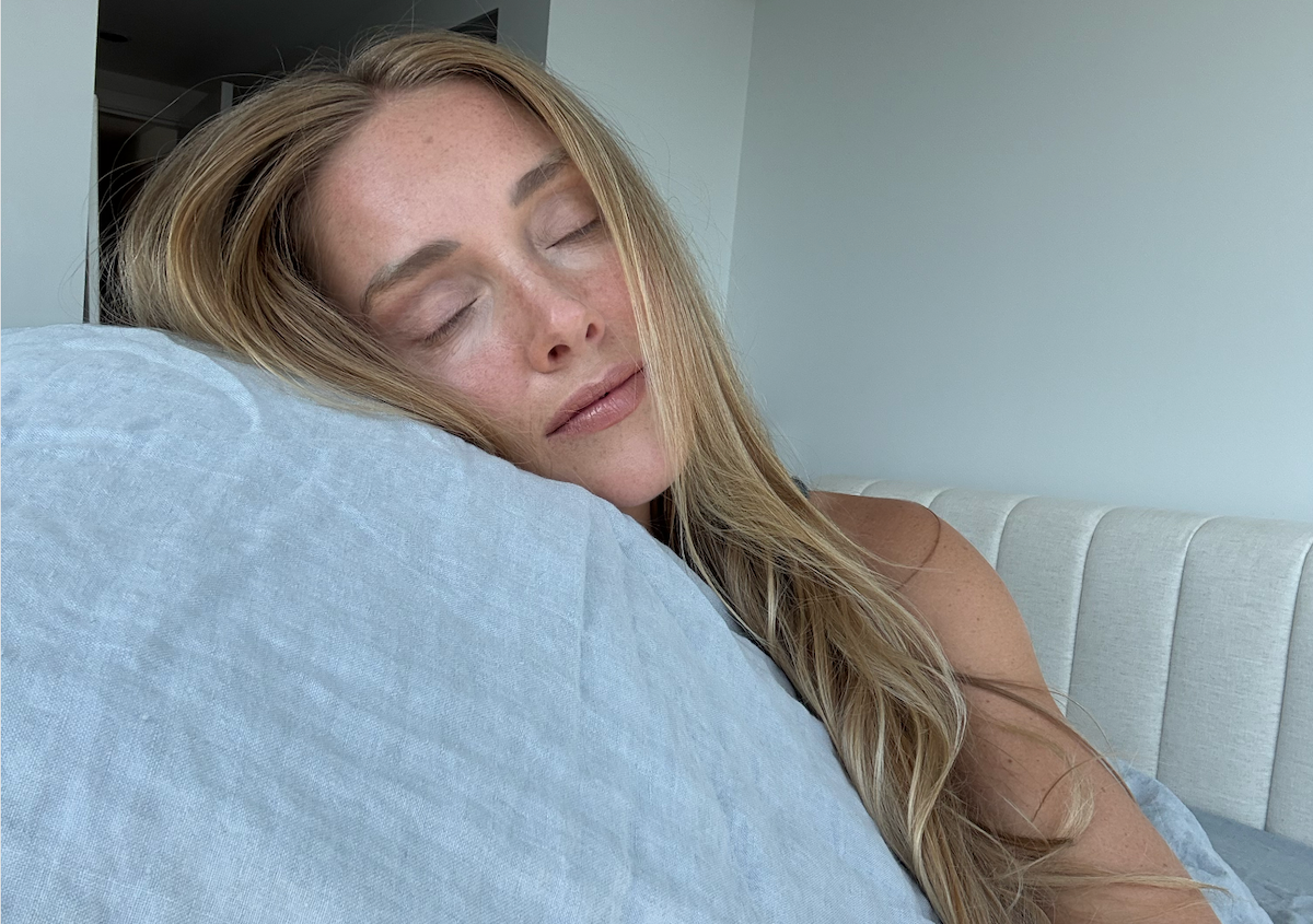 Woman sleeping on a pillow in a bedroom setting
