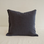 Dark gray pillow on a beige surface